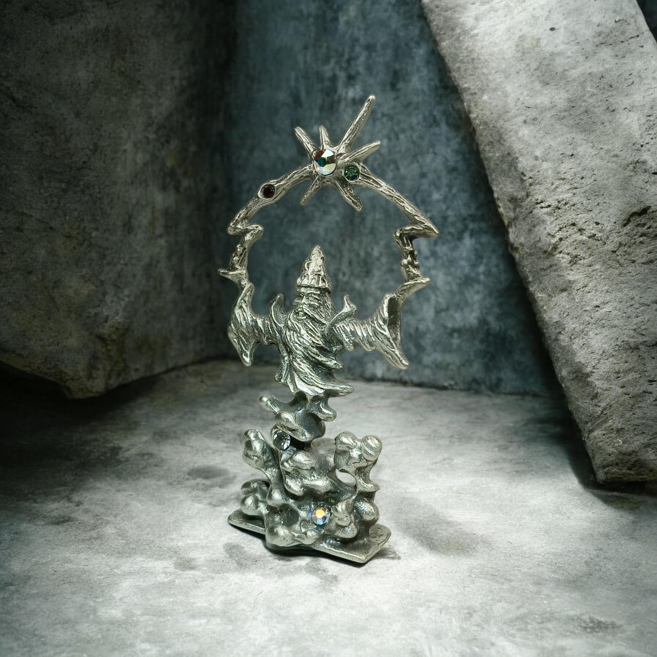Pewter wizard in a pointed hat and flowing robe, raising both arms beneath colorful accents.